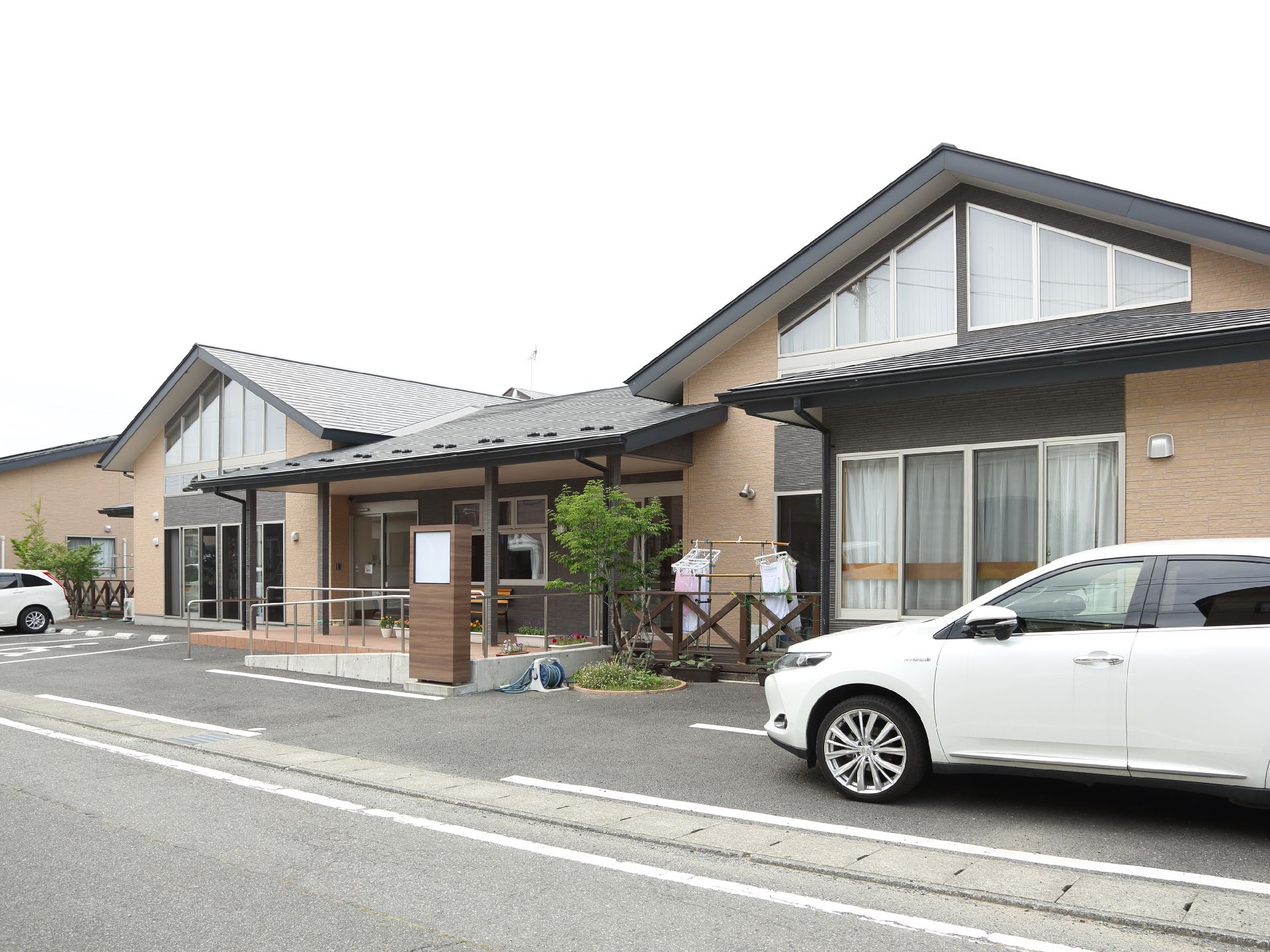 モダンな創りの施設にはの真ん中に玄関があり、手すりとスロープが設置されていて車いすの方でも安心の設計である。