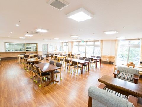 木目が美しいフローリングが広がる食堂である。多数の窓を設置して、日中には自然光で過ごせる明るい空間である。