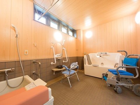 車椅子でも入ることのできる浴室は広く、タイプの違う浴槽がある。シャワーの前には浴用介護いすも備えてある。