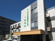 白い壁に緑の文字で施設名がはっきりと記されているので、来訪時に見つけやすい。玄関に黄土色の大きな屋根が付いているのが特徴である。