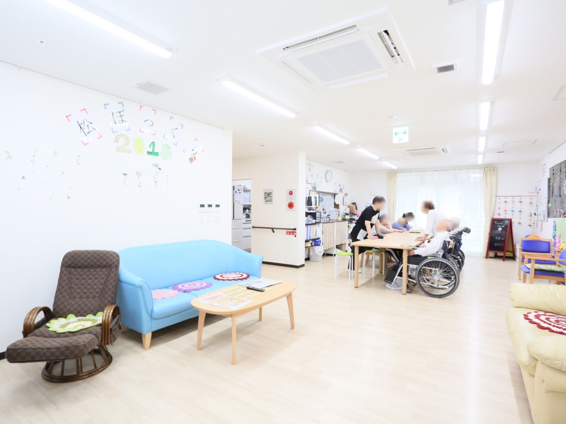 パステルカラーの大きめのソファが２脚向かい合わせに設置してある。一人掛けのリクライニングチェアも置かれている。