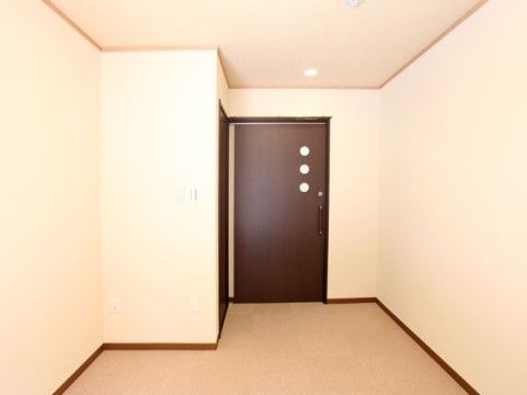 明るい色調に、濃い茶色の扉がアクセントになった居室である。扉には丸形の明かり窓が３つ備え付けられている。
