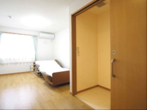 広々とした居室内には、トイレへ行くための引き戸がある。段差のないフラットな床になっており、安全に移動していただける。