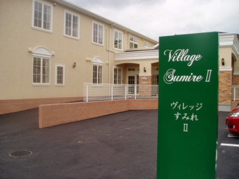 大きな駐車スペースが設置された、２階建ての施設の外観
