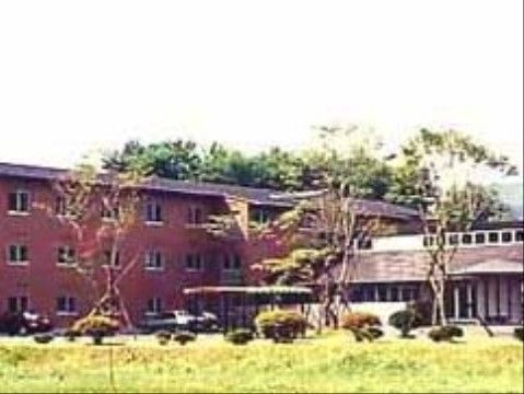 ブラウンの外壁の３階建ての建物である。広い敷地があり、建物の前には駐車スペースが用意されているので、車での来訪も便利である。