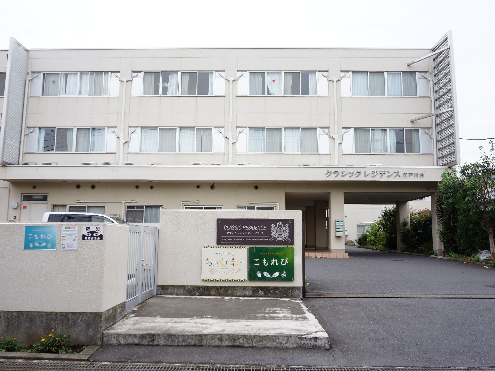 ３階建てのホームの玄関部分には、車が奥に出入りできるスペースが取られている。玄関屋根には、分かりやすく施設名が設けられている。