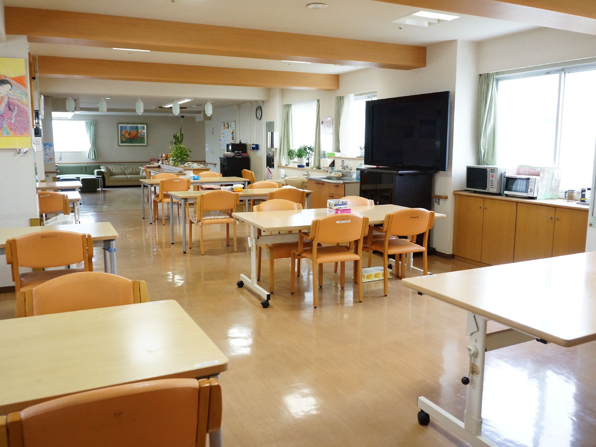 広々とした食堂には、大画面テレビが置かれており、見ながら食事ができる。部屋の片隅にはソファも置かれている。