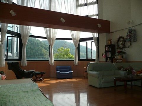 高い吹き抜けの空間に、太い梁が渡され良いアクセントになっている。安楽椅子やソファーなどの椅子が置かれ、好みの場所で寛ぐことができる。