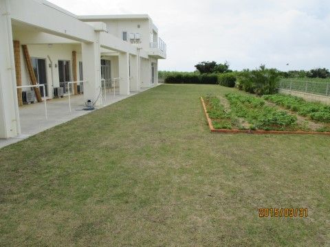 「グループホーム来間」の外観。白を基調にした建物。