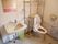 温水洗浄便座器が完備されているトイレである。壁には手すりが設置され、手洗い場に鏡も取り付けられている。