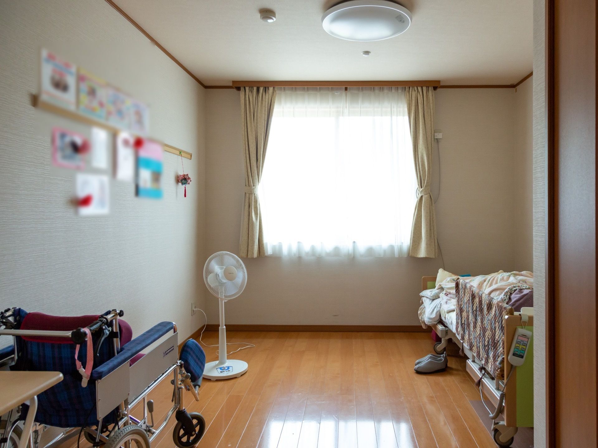 居室の奥には窓が配置され、その脇に介護用ベッドが置かれている。部屋の真ん中は通路として広く空けてある。