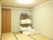 畳敷きの部屋には埋め込み式のエアコンが設置されている。造り付け収納が完備されている。パイプ式棚には敷布団やシーツ、上掛け布団が積まれている。