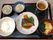 ステージで行われた敬老の集いを、椅子に座って楽しむ入居者様。ステージ上では丈の長い衣装を着た人達が、出し物を披露している。