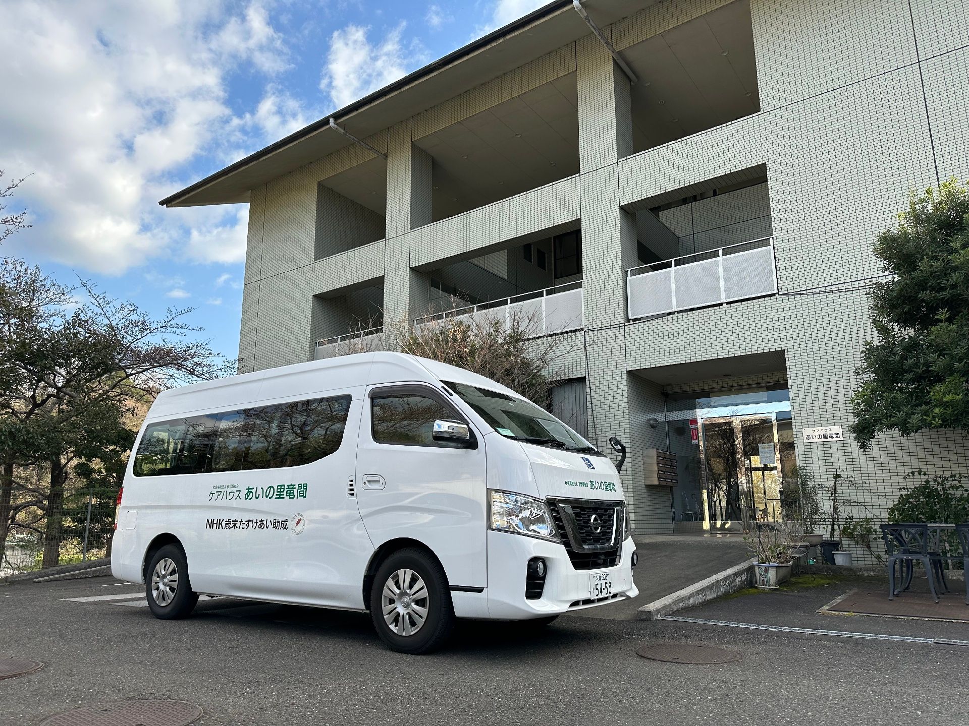 大きな屋根があり、ガラス張りの自動ドアが設置された玄関