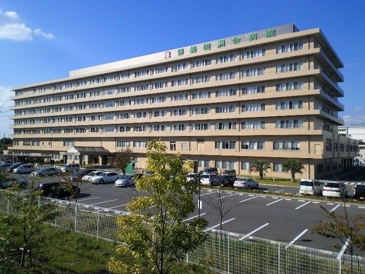 車ですぐのところにある４階建ての病院の外観。診療科目は内科やリハビリテーション科などで本格的なリハビリ施設が完備されている。
