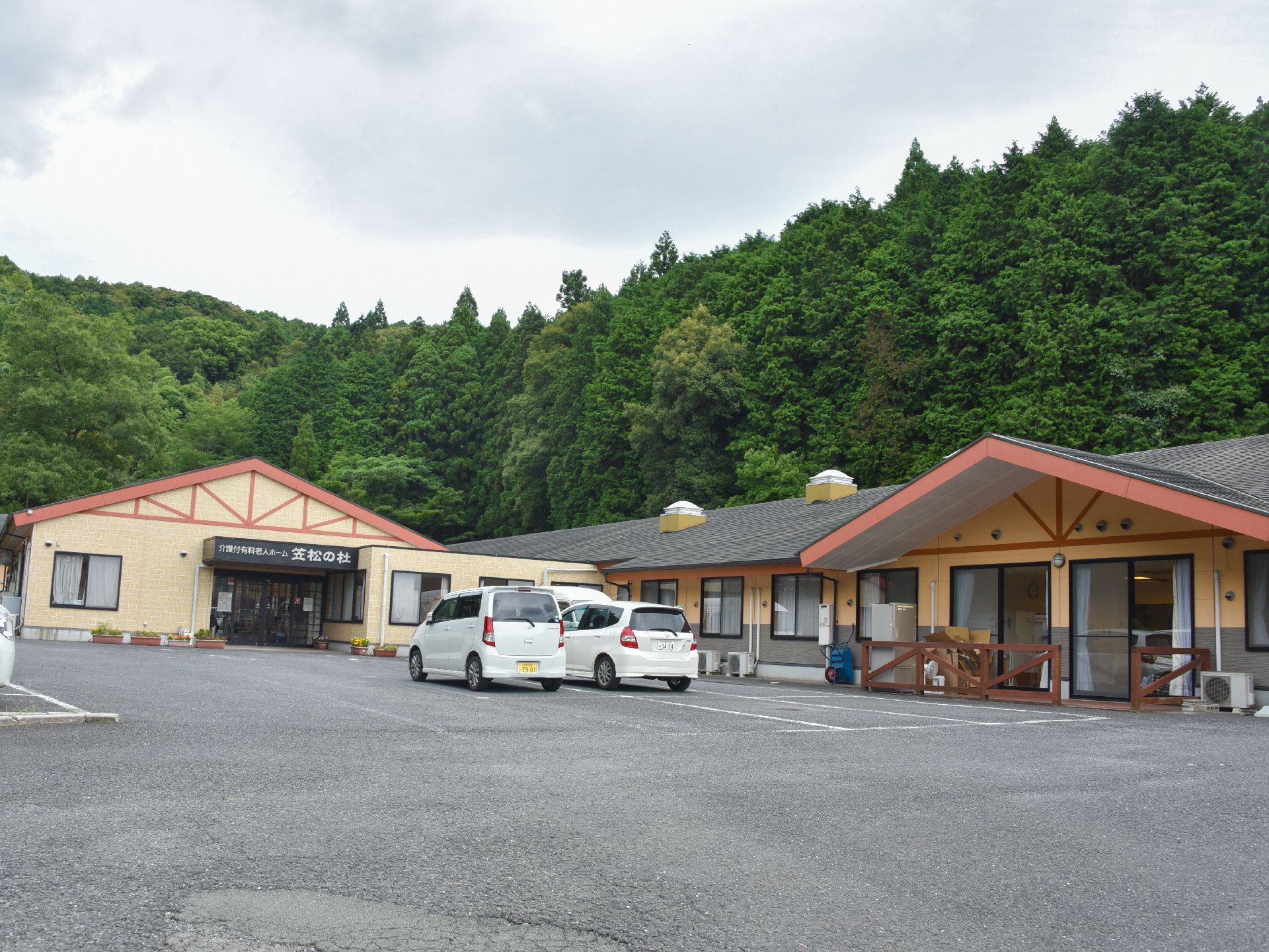大きな駐車スペースが設置された、広い敷地に建つ施設