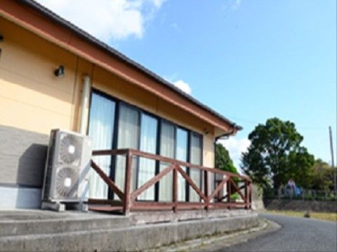 １階の窓部分にウッドテラスが設置されている施設の外観