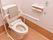 ナースコールの常備された清潔なトイレの個室。便座には肘掛が付き、手すりも設置されており、安心してご利用になれる。