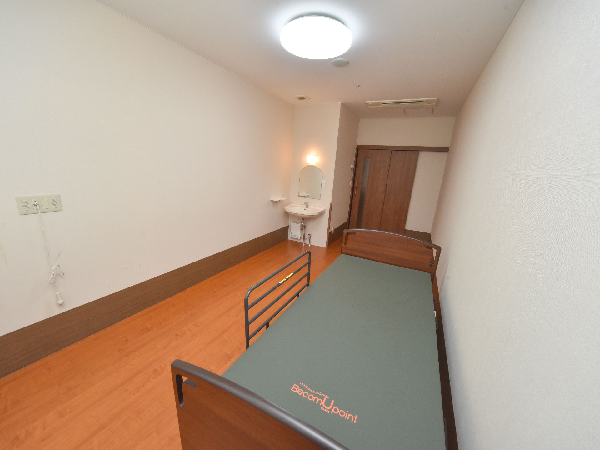 居室には介護用ベッドが設置されている。転落防止用の柵を設置しており、立ち上がる際の支えにもなっている。