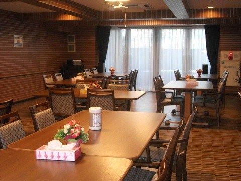テーブルにティッシュ、ウエットティッシュ、お花が置かれ、ブラウン系のインテリアでまとめられたダイニングルーム