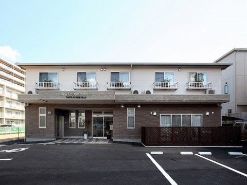 ２階建ての横長の建物。1階は茶色、2階は白で塗り分けられている。向かって左に玄関があり、両開きの自動ドアが見える。