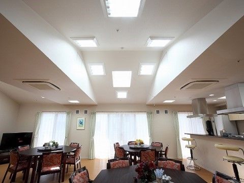 白い天井が明るいフロアに六角形のテーブルセットが３つ置いてある。右手にはキッチンとカウンターがあり、スツールが２つ備え付けてある。