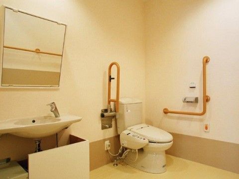 独立した洗面台が設置された、呼び出しボタンのある広々としたトイレ