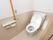 トイレの壁は２色に分かれていて、上半分は白、下半分はベージュとなっている。床の色もベージュで揃えられている。