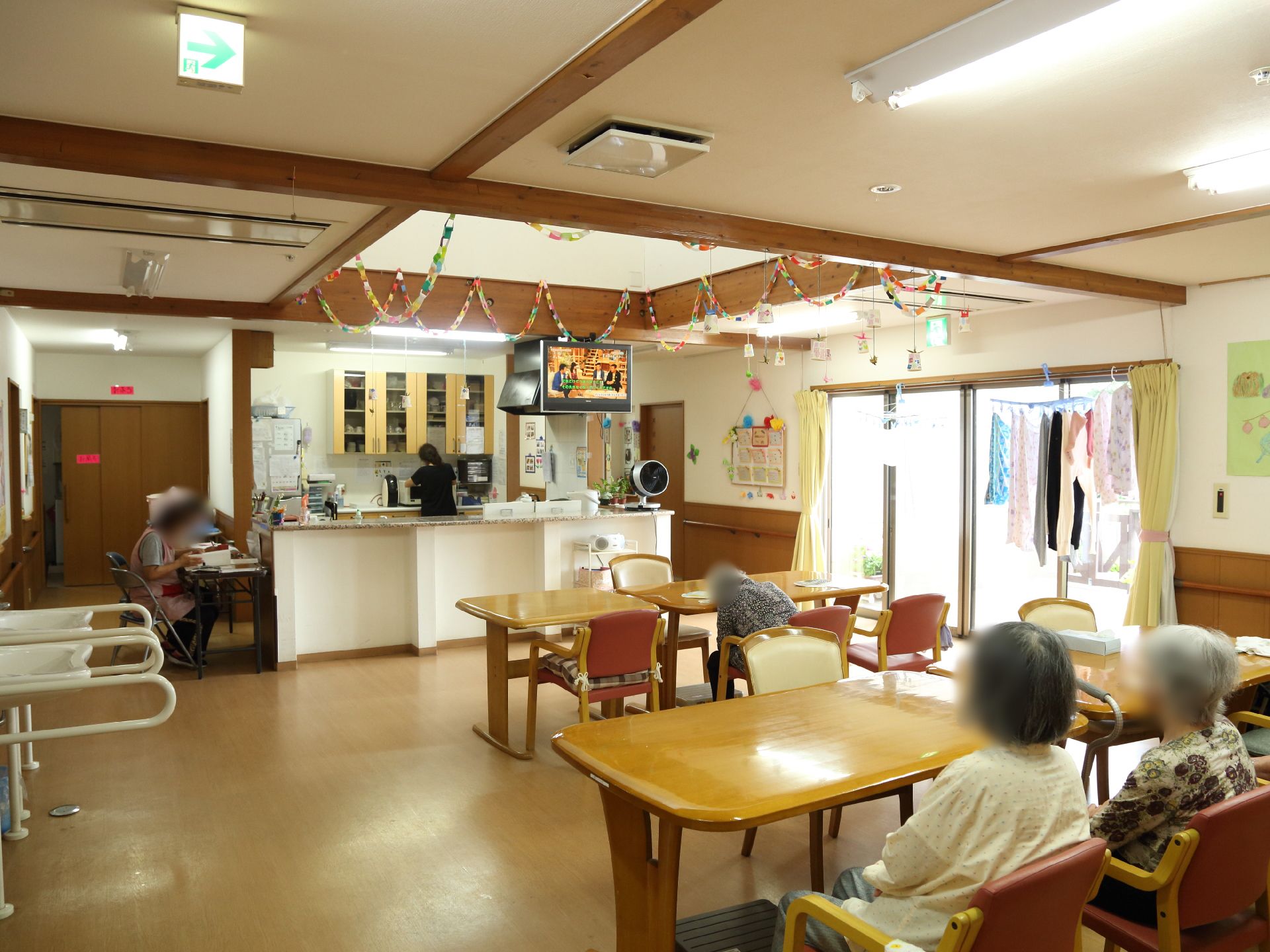 洗面所があり、手すりが設置されている。テーブルや椅子が置かれており、ゆっくり過ごすことができる。広いリビングとなっている。