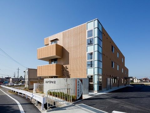 広い敷地の中に建っている、ブラウン色の外壁の施設外観