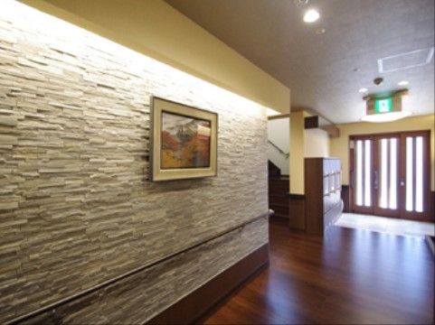 幅が広く、壁に絵画が飾られた落ち着いた雰囲気の廊下