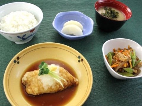 ご飯、お味噌汁や魚といった和食のメニューである。煮物があり、野菜もしっかりと摂取できる。食事は品数が多く、食べ応えがある。