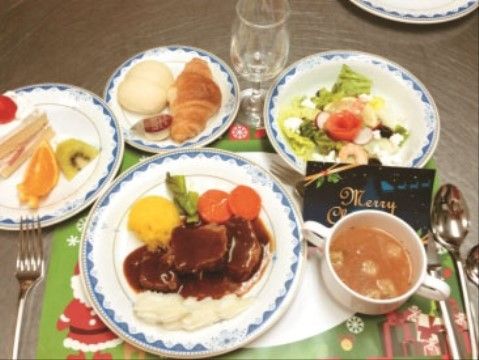 いくつかの小皿に料理が綺麗に盛り付けられている。クリスマスのため料理が豪勢であり、ケーキも用意されている。