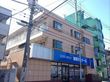 ベージュ色の外壁で、ベランダが上階に設置された３階建ての施設外観