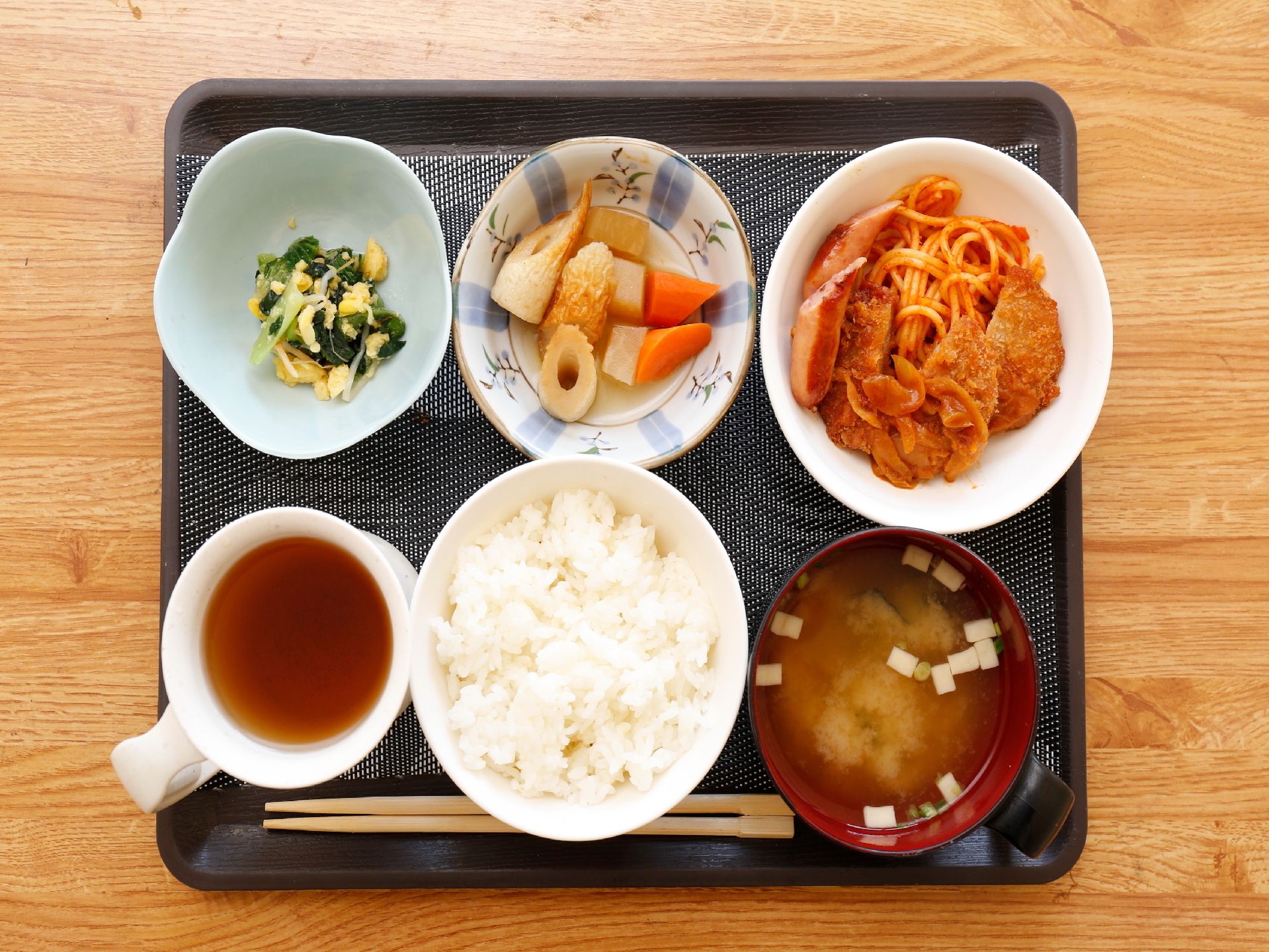 お盆の上にはご飯と汁物のお椀、おかずが3皿に飲み物のコップがのっている。メニューは彩りにも気を配って作られている。