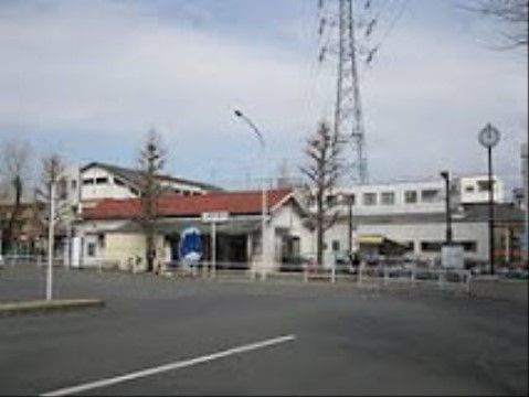 赤い屋根の小さな駅に電車が停車している。駅の前は広いスペースがとってあり、静かで落ち着いた雰囲気がある。
