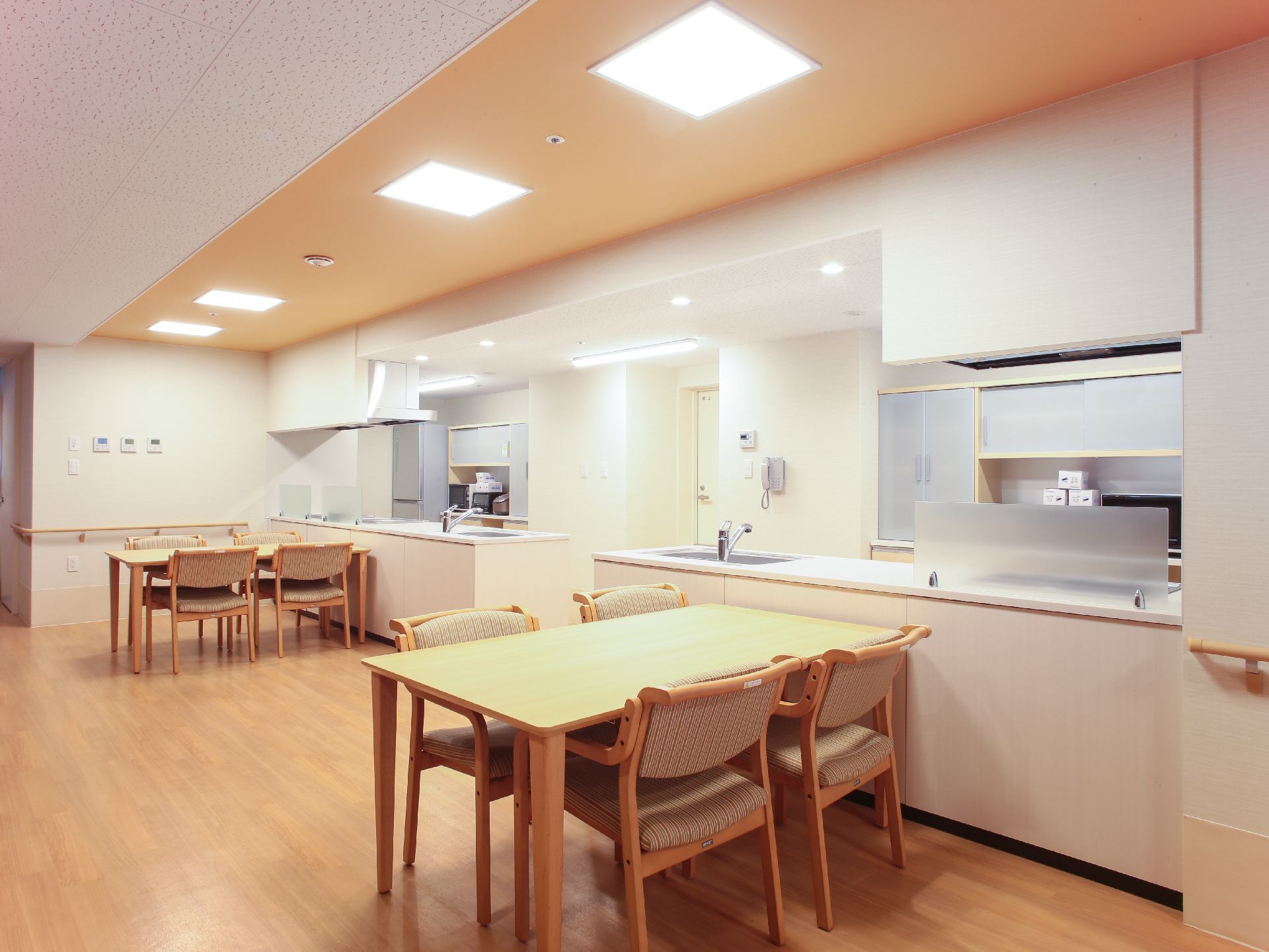 入居者に食事が提供される食堂。いくつかの座席が用意されていて、カウンターの向こう側には食器洗い場がある。