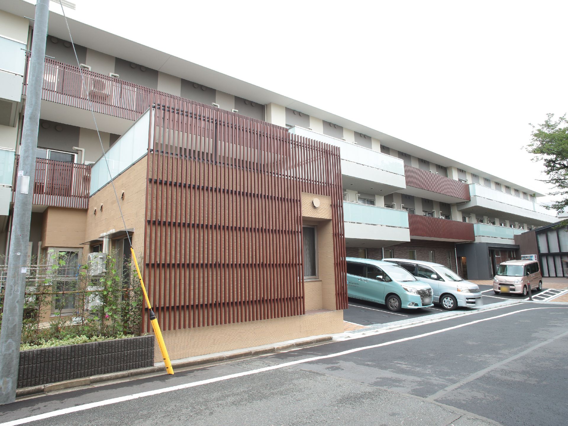建物前に駐車スペースが確保された、ブラウン色が基調となった施設外観