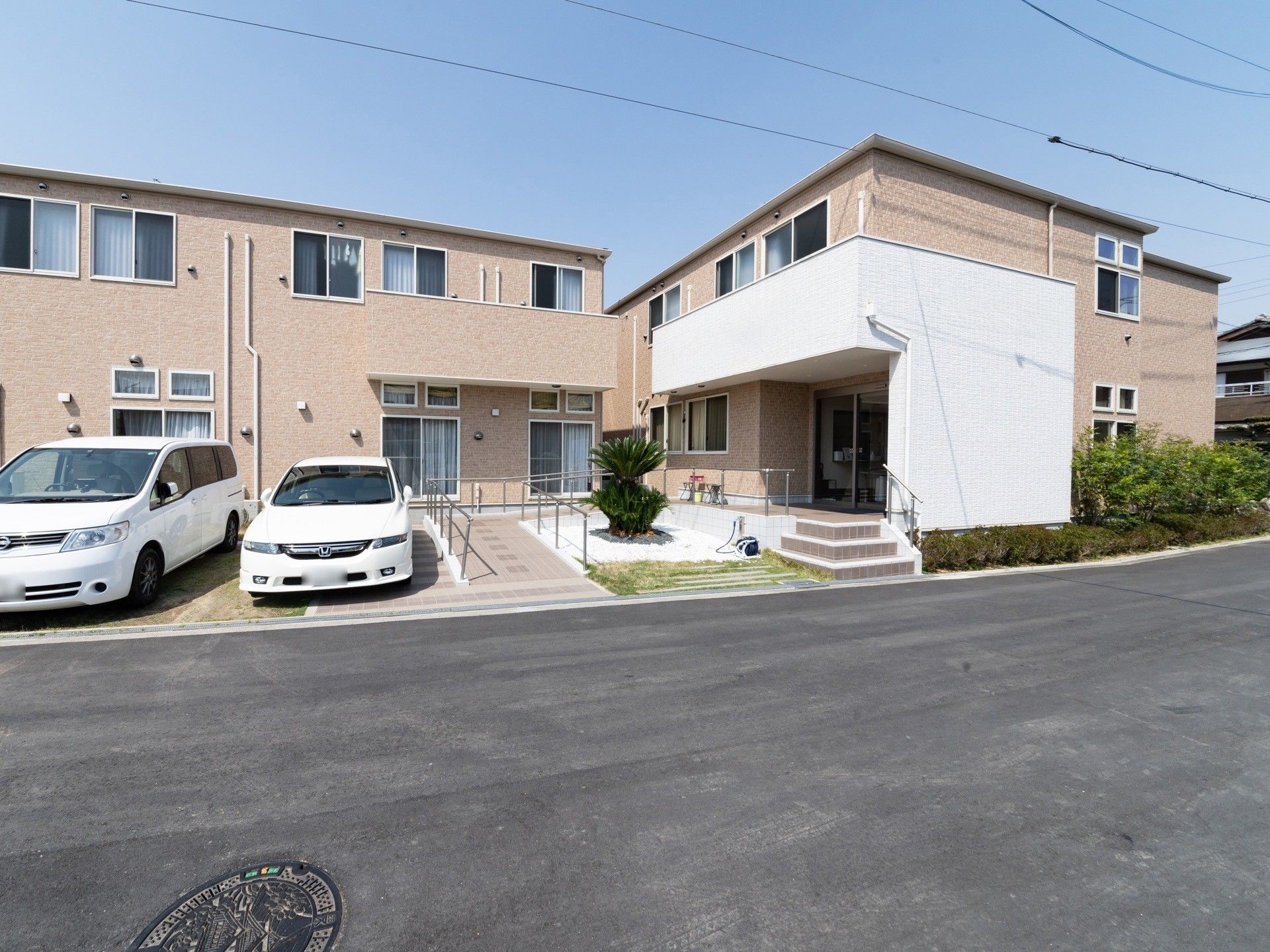 ２階建てで建物の前に駐車スペースが設置されている。段数の少ない階段と傾斜が緩やかなスロープが用意されている。