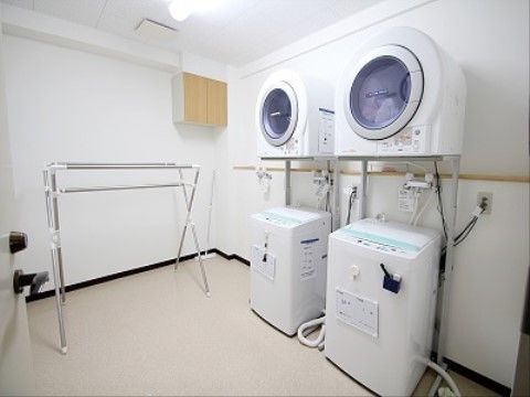施設にはランドリー室があり洗濯機と乾燥機を2台ずつ準備している。物干し竿もある。雨の日でも気にせずに洗濯ができる。