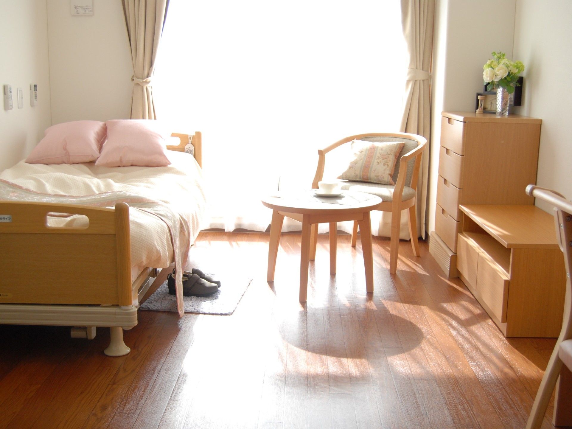 ベッドやチェストなどの家具の色調が統一された清潔感のある部屋である。大きな窓から日差しが入り、室内はとても明るい。