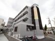 隣接する建物とは、ブロック塀で仕切られている。施設の建物の前に自転車が置いてあり、その奥には物置がある。