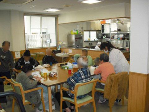 複数名の入居者が同じテーブルにつき、それぞれ思い思いの時間を過ごしている様子