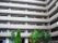 一般的なマンションと変わらない、静かで落ち着いた印象の施設外観の光景。手前には、中庭に植えられた若い木々も写っている。