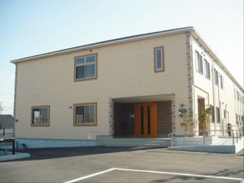 レンガでのお洒落な装飾が印象的な、2階建て入居施設の正面出入口