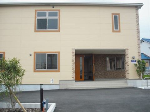 一階の入口部分の壁はレンガ調になっている。玄関へ上がるところは階段になっているが、側にはスロープになっているところがある。