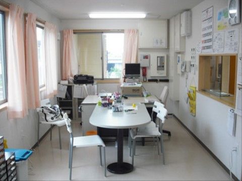 椅子やテーブルがあり、スタッフがいつでも待機できる空間になっている。呼び出しに対応するボードが設置されている。