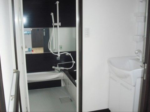 扉を開けると右側に洗面台がある。更に扉を開くと浴室がある。浴槽はまたぎが低いタイプで、高さが変えられるシャワーがある。