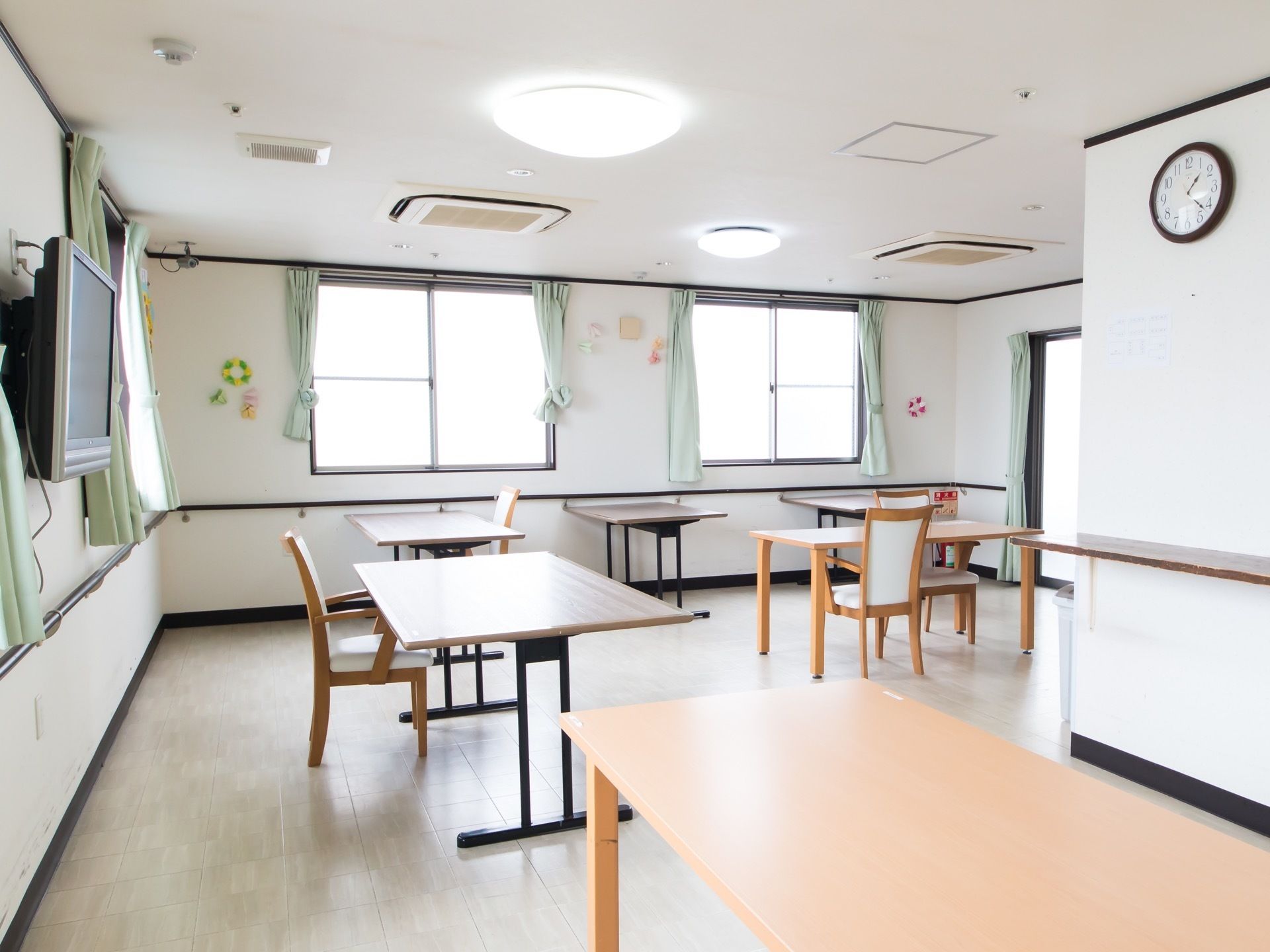 テーブルと椅子が設置された共有スペースである。椅子にはひじ掛けが付いており、立ち上がる際に体を支えることができる。