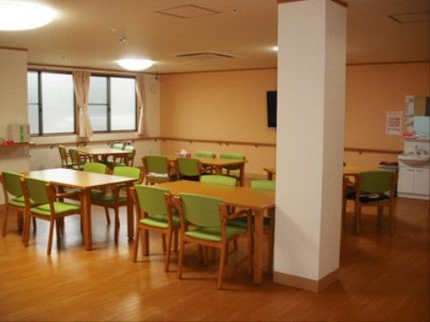 食堂の壁には長い手すりが設けられているため、掴まって安全に歩いていただける。テーブルの周りには椅子が置かれている。